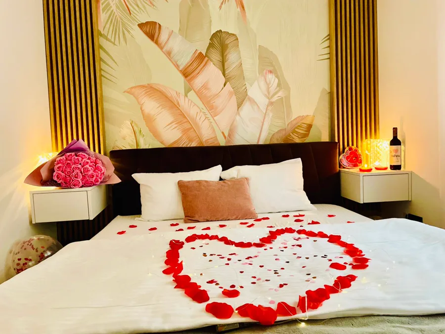 Dormitor romantic decorat cu petale de trandafir în formă de inimă